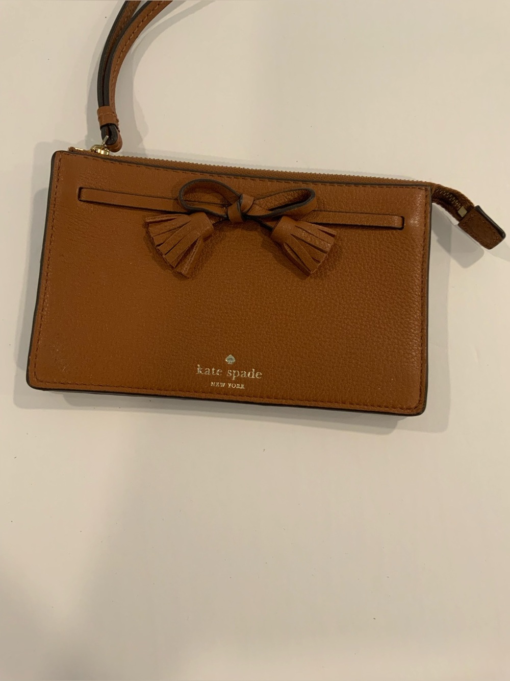 Kate Spade tan leather wristlet with tassel bow detail